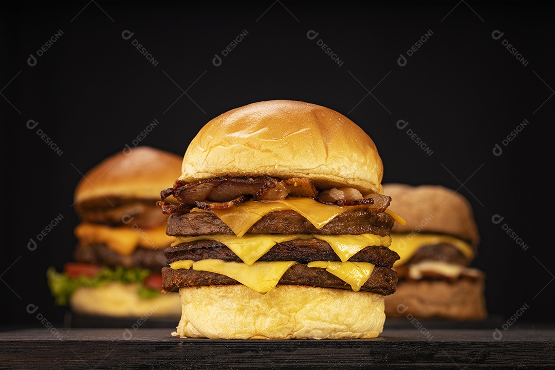 Três hamburgueres triplo sobre fundo preto