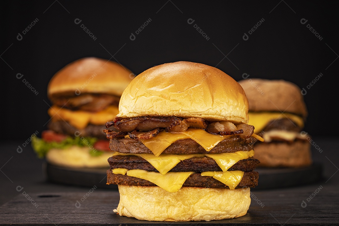 Três hamburgueres sobre fundo preto