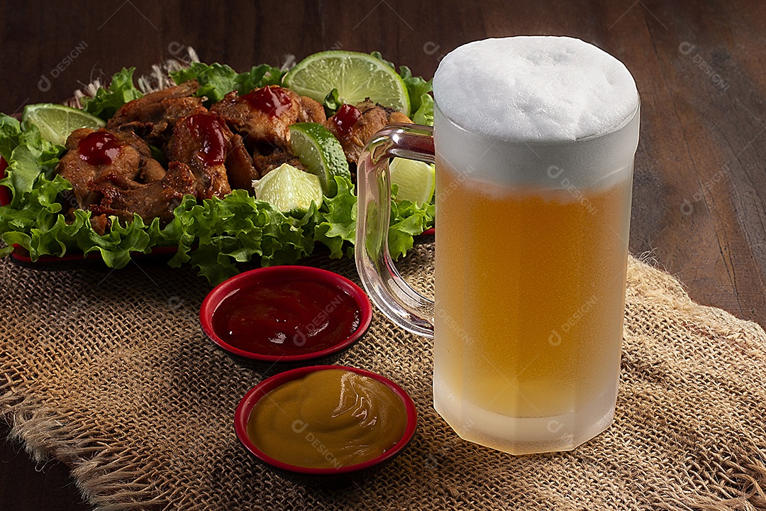 Caneca de cerveja gelada com porção de frango frito