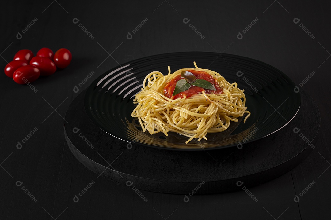 Macarrão ao molho de tomates em um prato preto