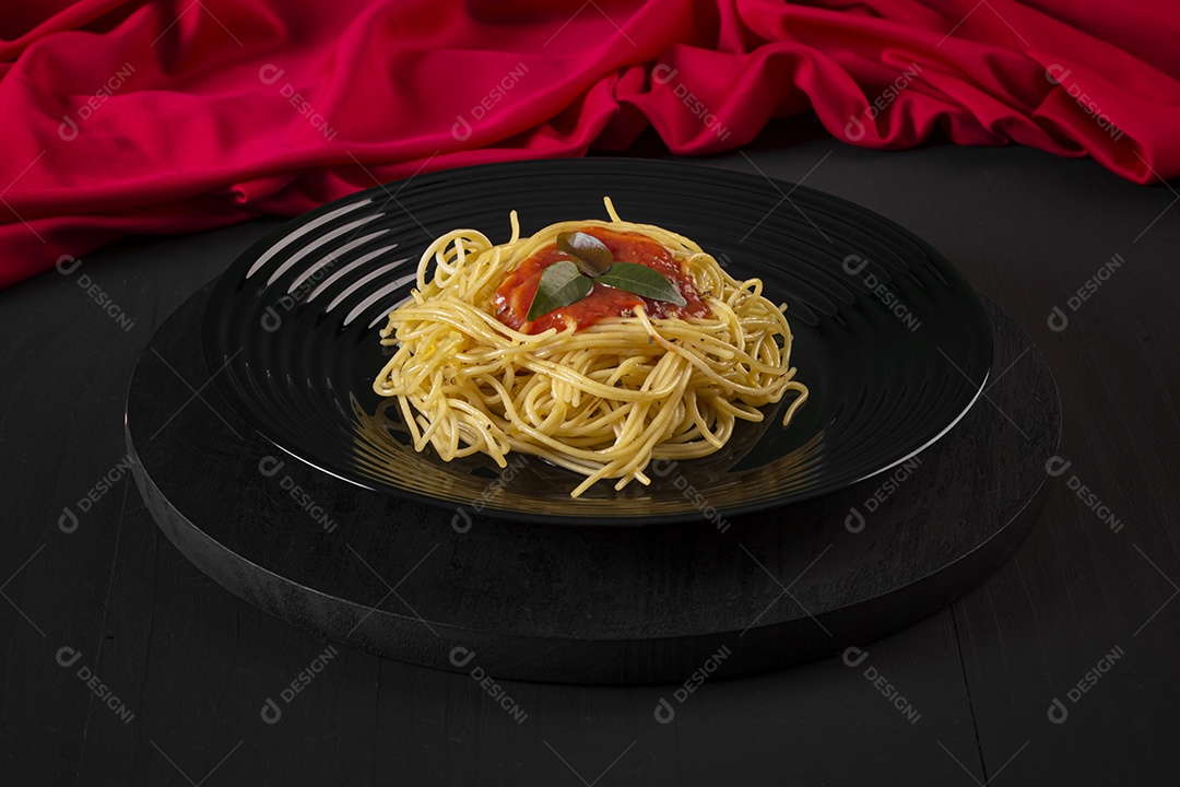 Macarrão com molho de tomate em um prato preto