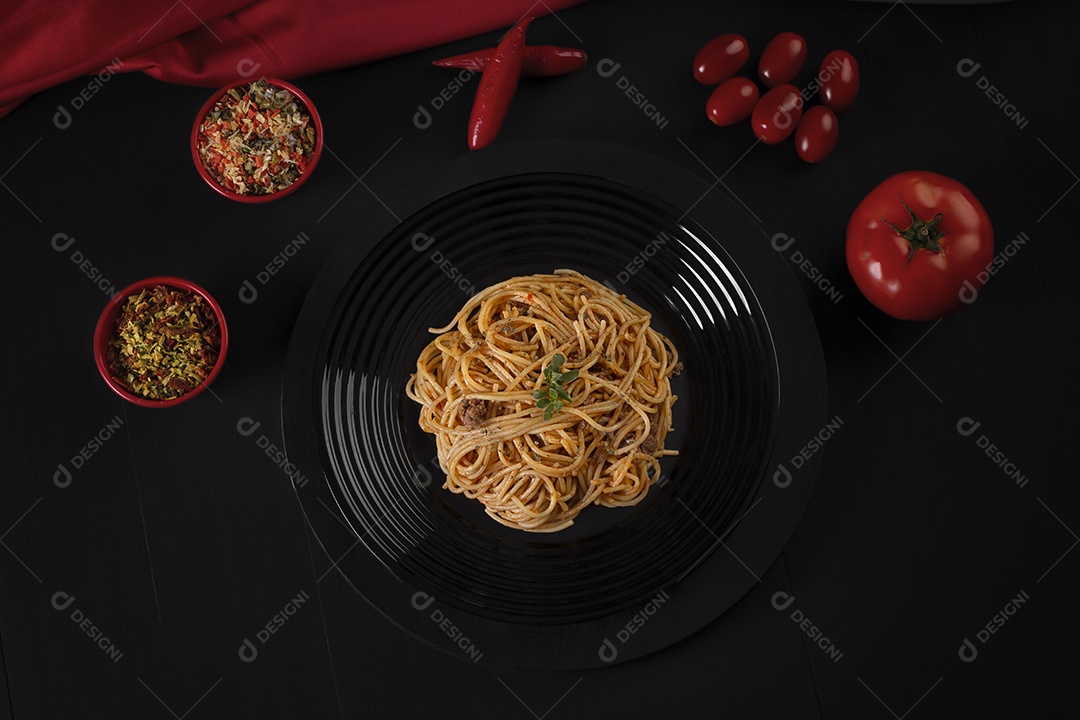 Prato preto com espaguete ao molho com tomates ao lado