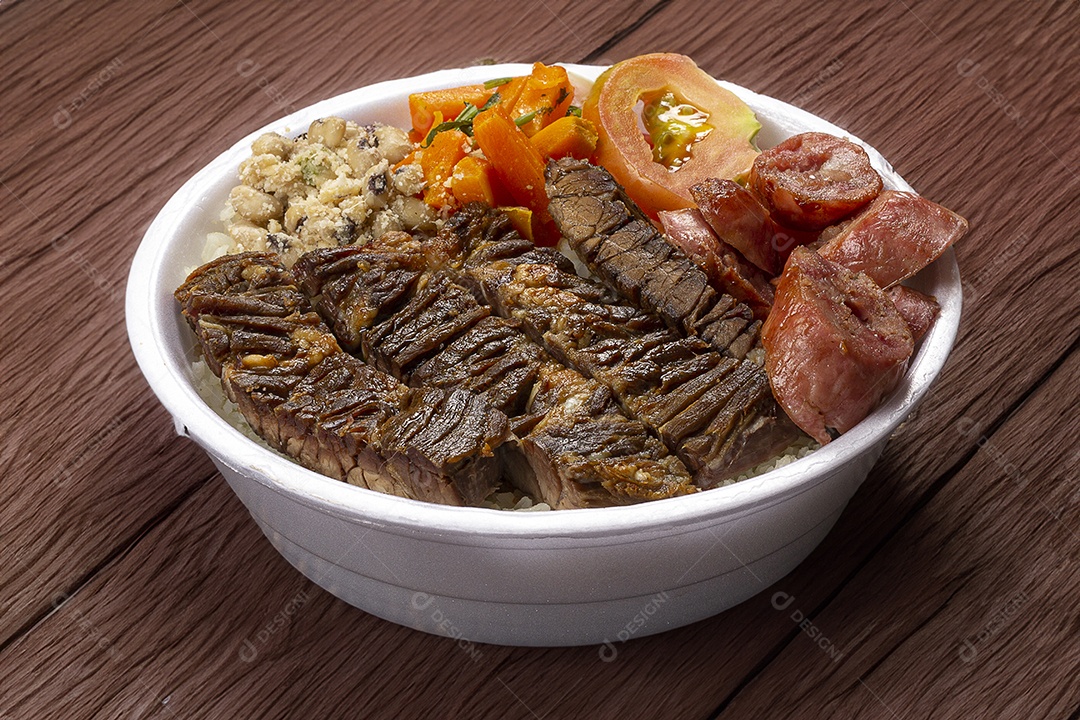Marmita de churrasco com salada de tomate sobre mesa de madeira