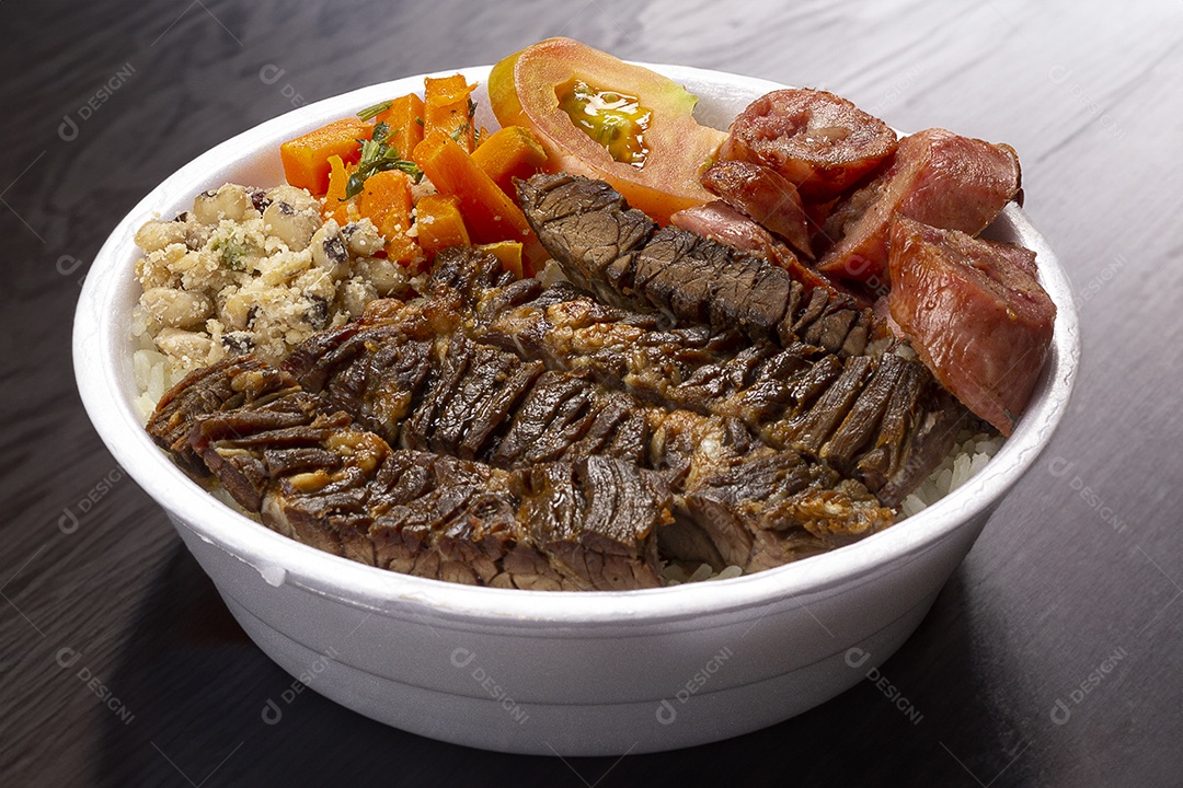 Marmita de churrasco com salada sobre mesa de madeira