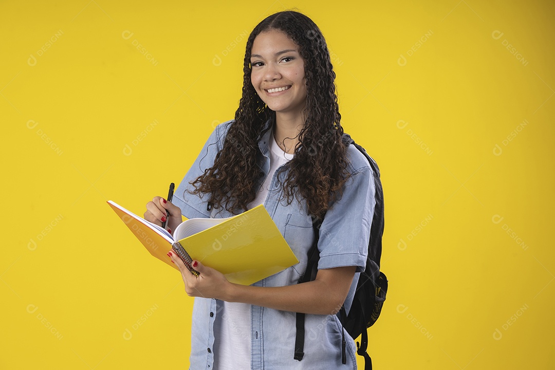 Garota sorridente escrevendo no seu caderno