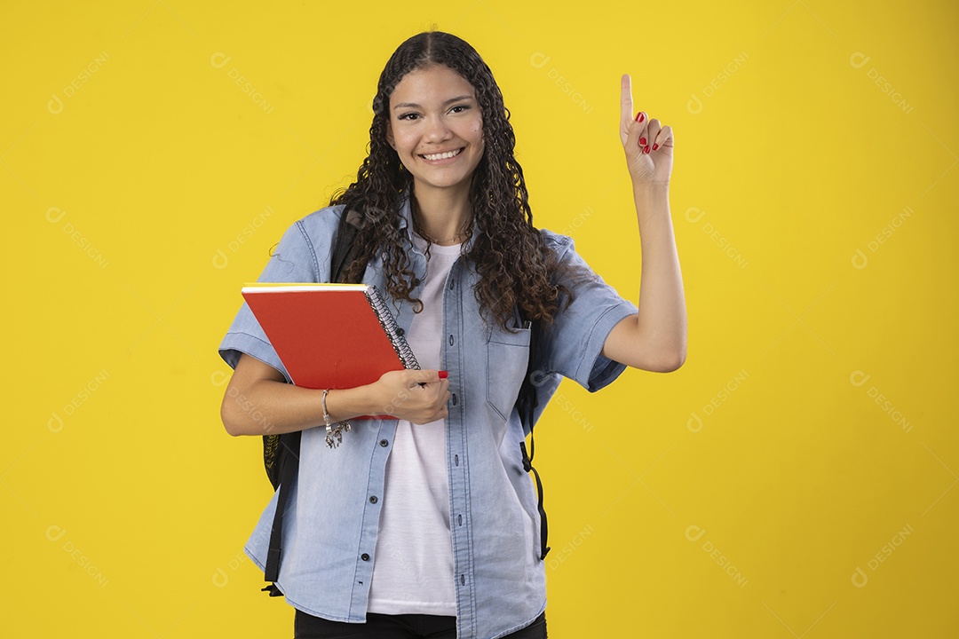 Jovem contente com livros nas mãos apontando para cima