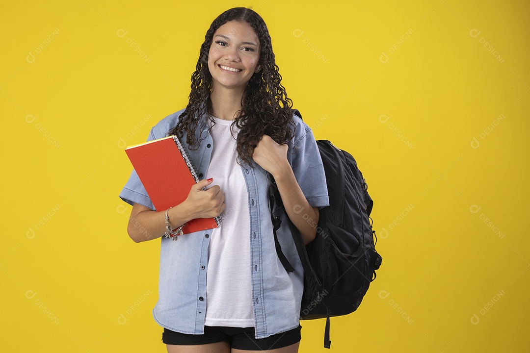 Uma linda garota estrudante segurando caderno com mochila nas costas