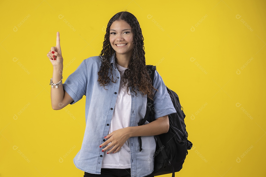 Linda jovem sorrindo apontando para cima com mochila nas costas