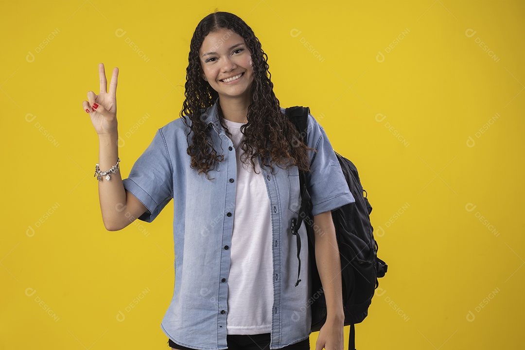 Linda jovem com mochila nas costas e fazendo sinal de dois dedos