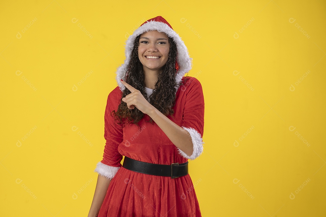 Jovem vestida de mamãe noel apontando para cima