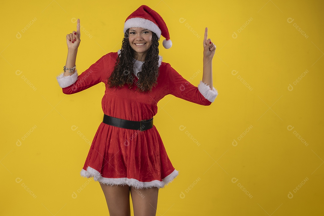 Linda jovem com fantasia de natal apontando para cima