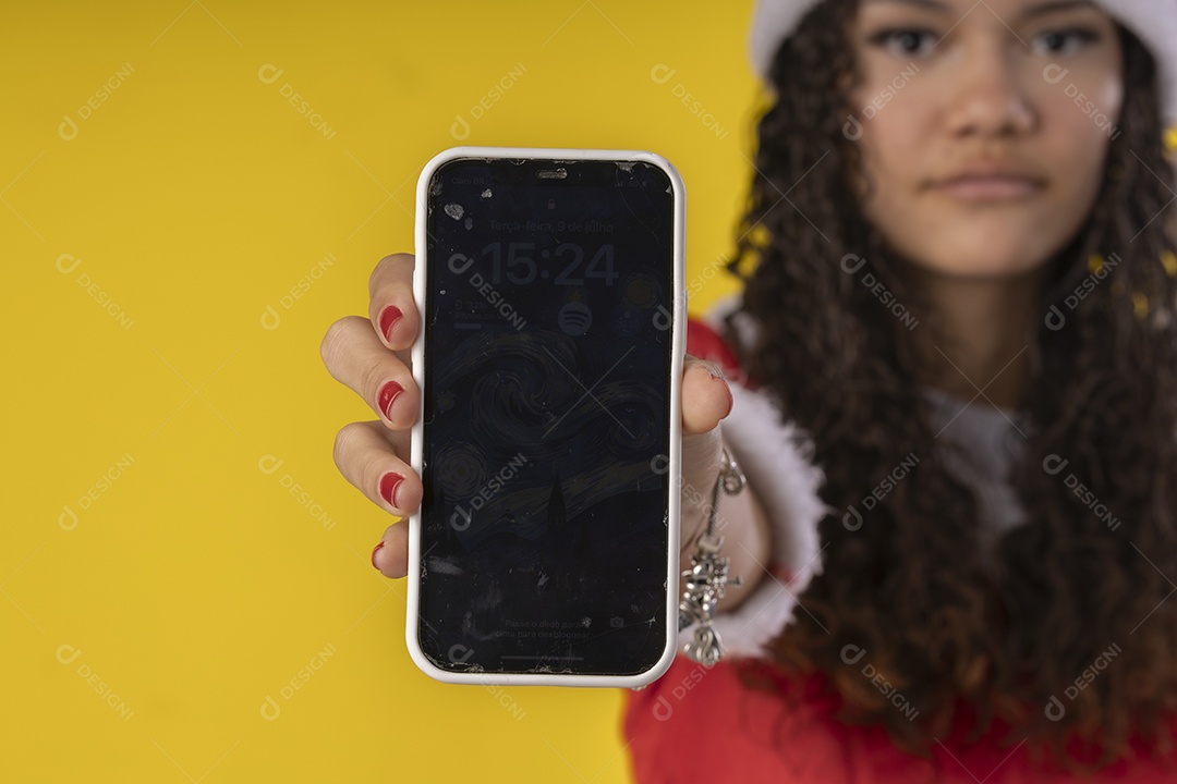 Jovem com celular nas mãos vestida de mamãe noel