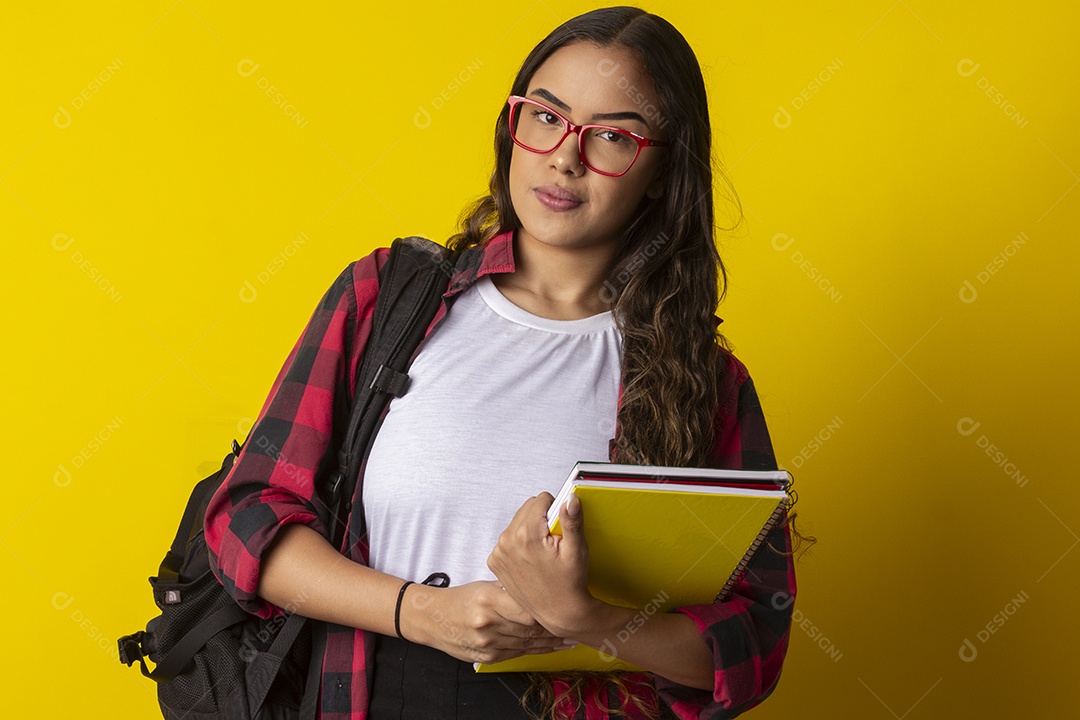Menina com mochila nas costas segurando livros nas mãos indo a escola
