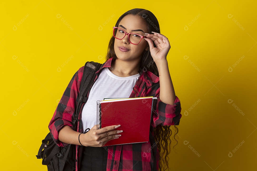 Menina com livros nas mãos e mochila nas costas