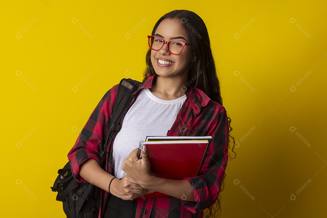 Menina sorrindo com mochila nas costas e livros nas mãos