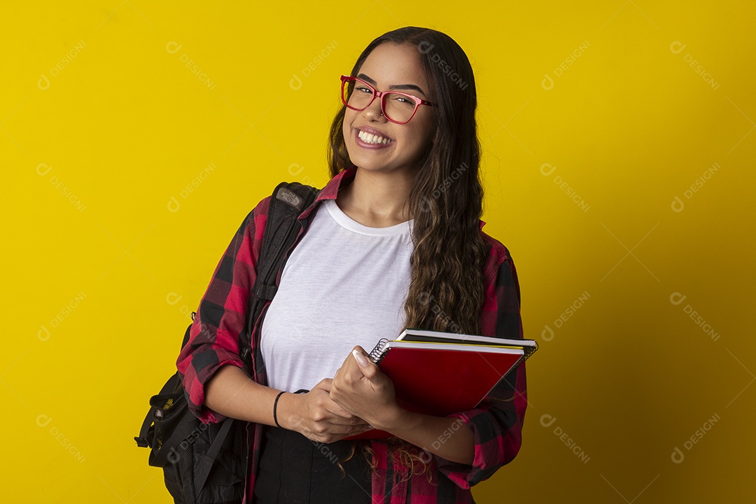 Jovem estudante com mochila nas costas e livros na mãos