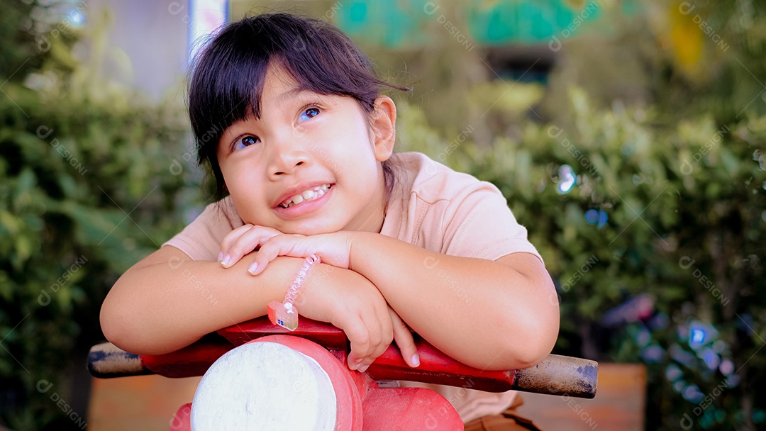Uma adorável menina sentada na sua motinha
