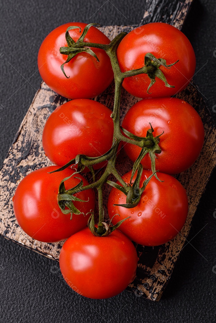 Tomates e temperos sobre uma tábua de madeira