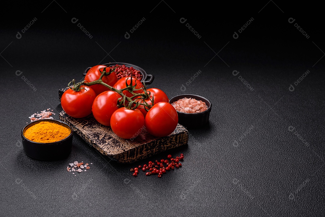 Tomates e temperos sobre tábua de madeira