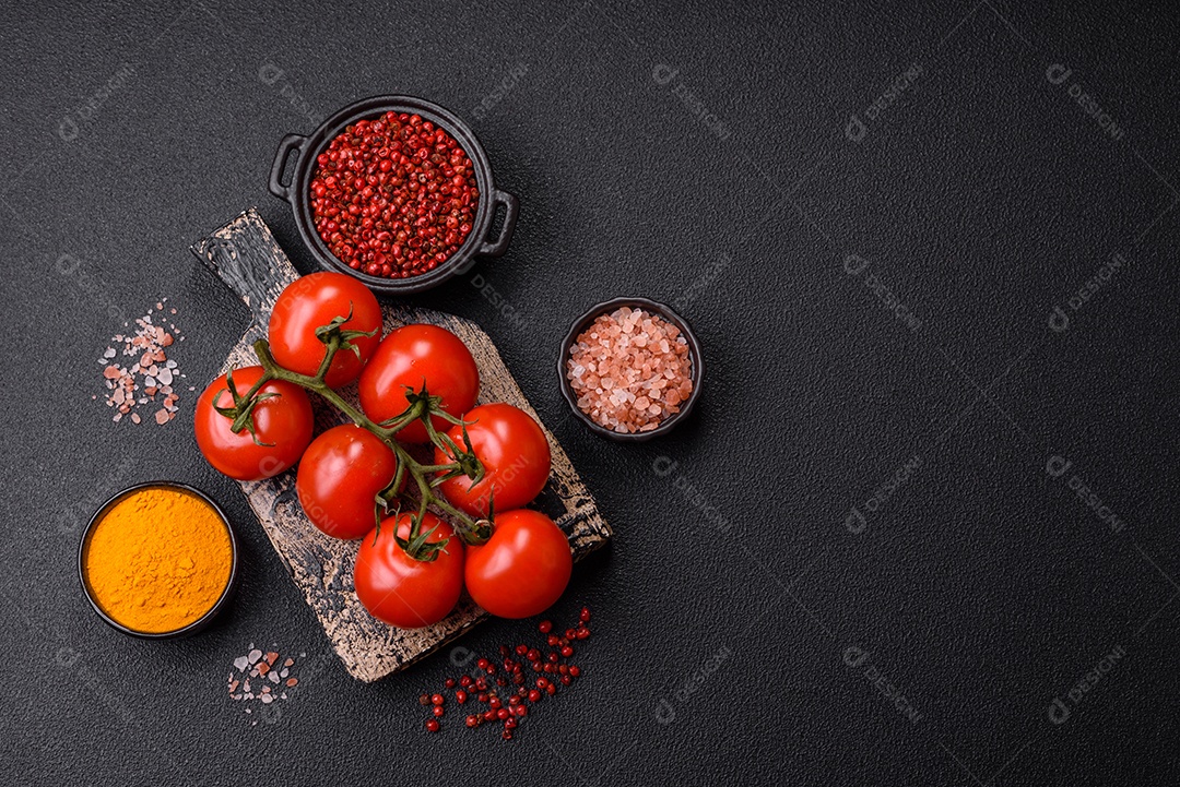 Tomates e temperos sobre tábua de madeira