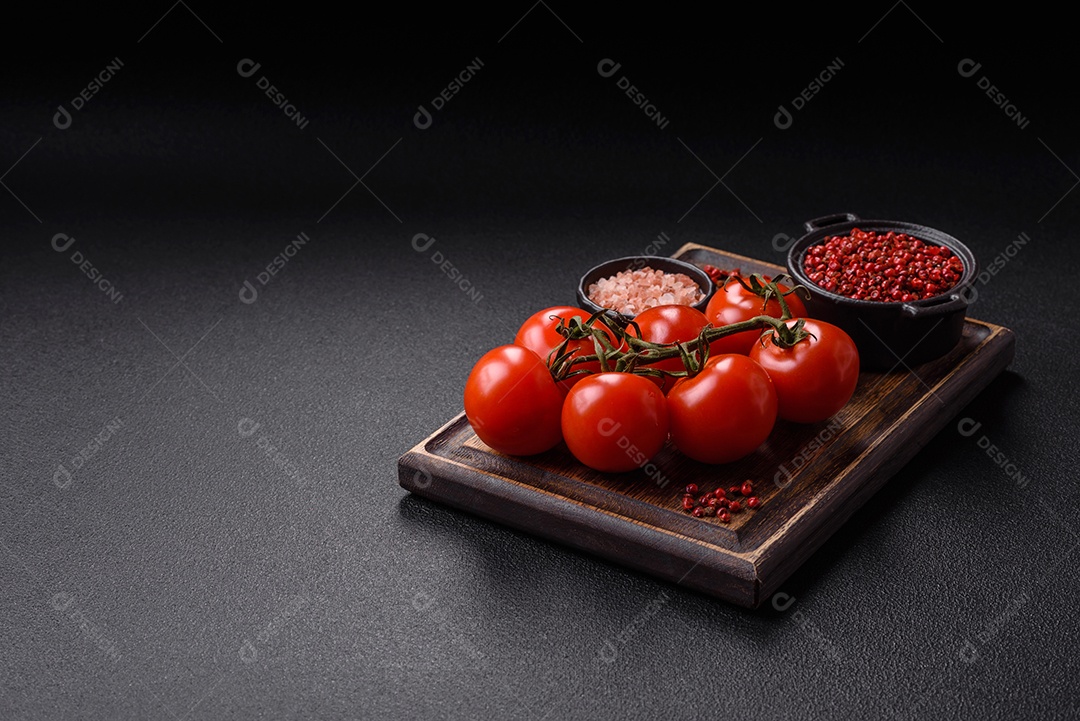 Tomates e temperos sobre tábua de madeira