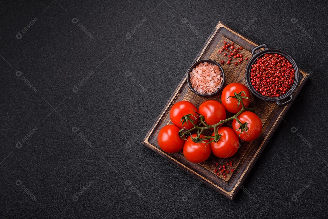 Tomates e temperos sobre uma tábua de madeira