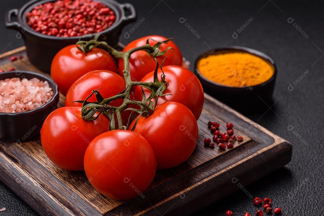 Tomates e temperos sobre uma tábua de madeira