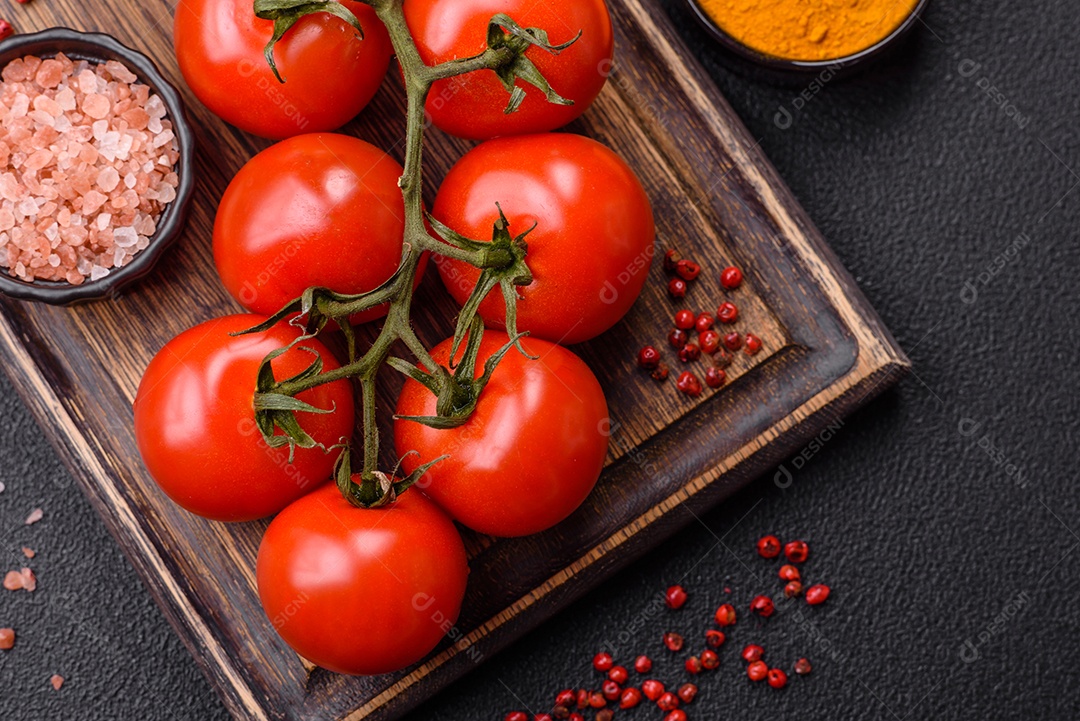 Tomates e temperos sobre uma tábua de madeira