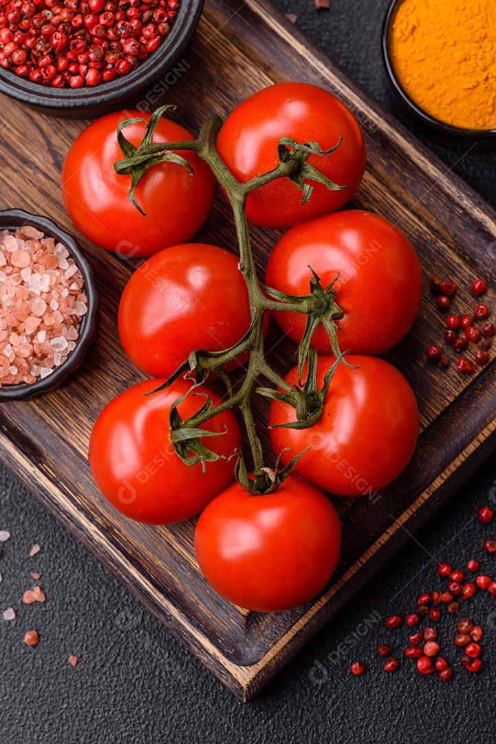 Tomates e temperos sobre uma tábua de madeira