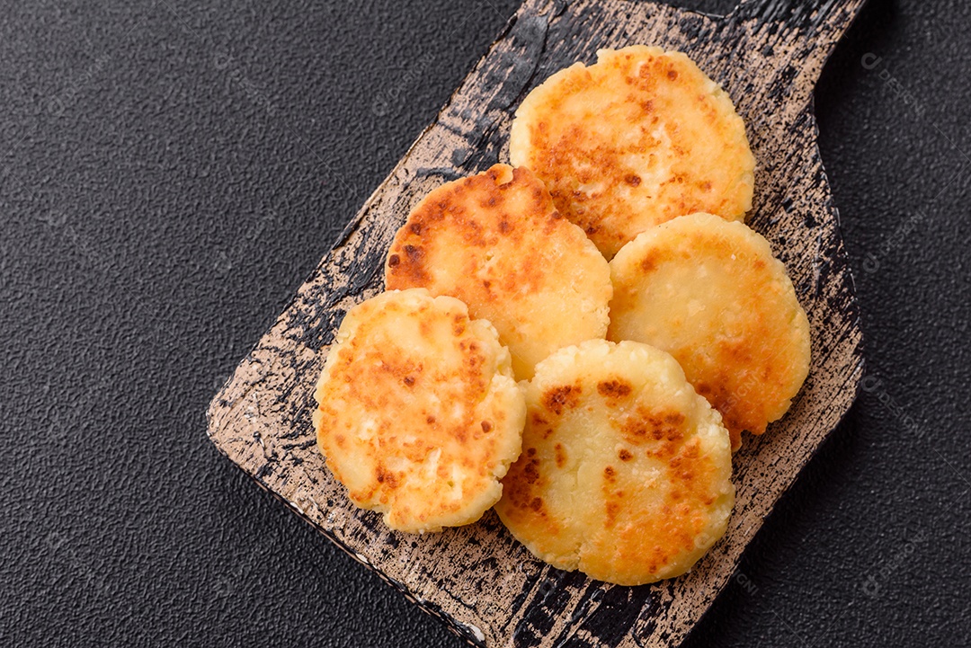 Panquecas de queijo doce deliciosas sobre tábua de madeira