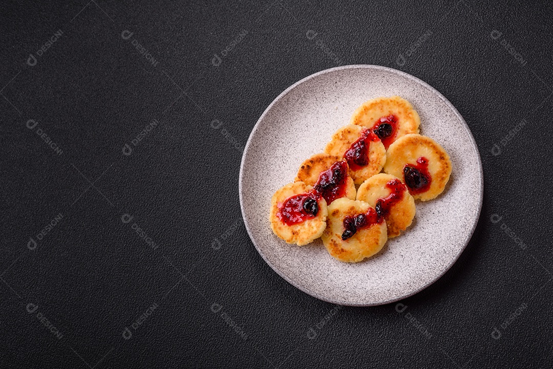 Panquecas de queijo doce fresco com passas e canela num prato de cerâmica