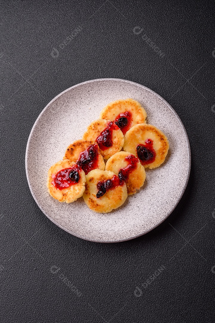 Panquecas de queijo doce fresco com passas e canela num prato de cerâmica