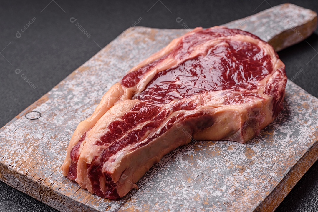 Carne em pedaço cru sobre tábua de madeira