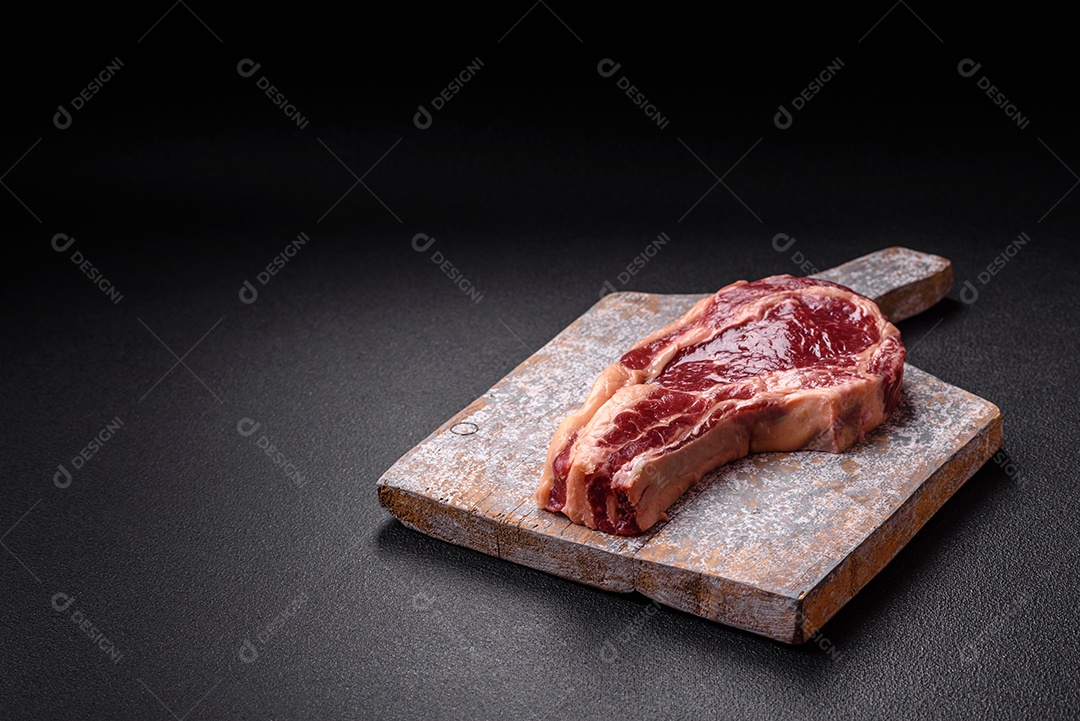 Bife grande de carne sobre tábua de madeira