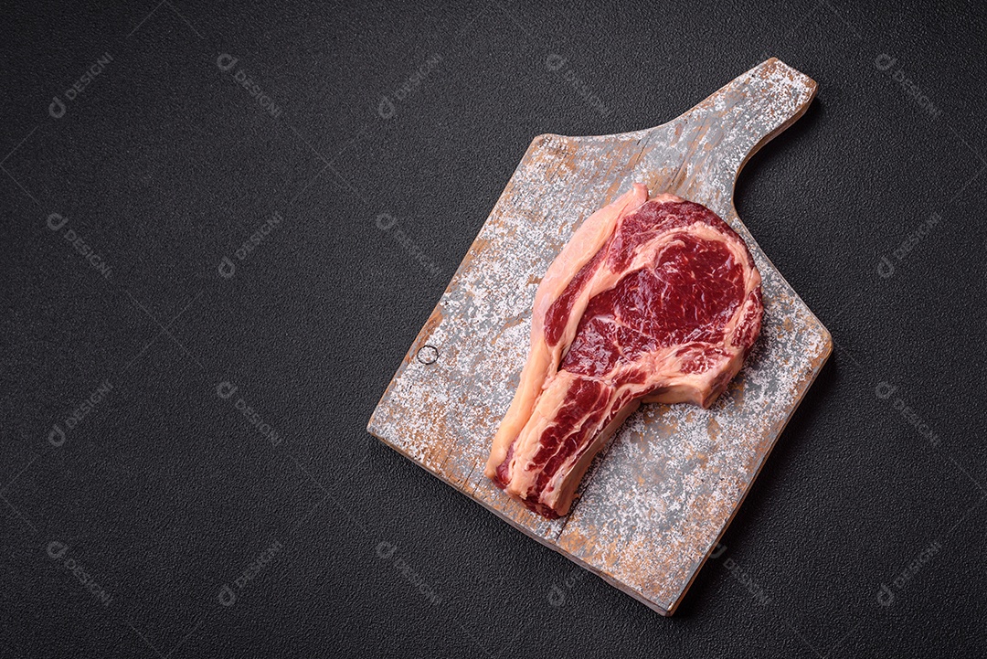 Bife grande de carne sobre tábua de madeira