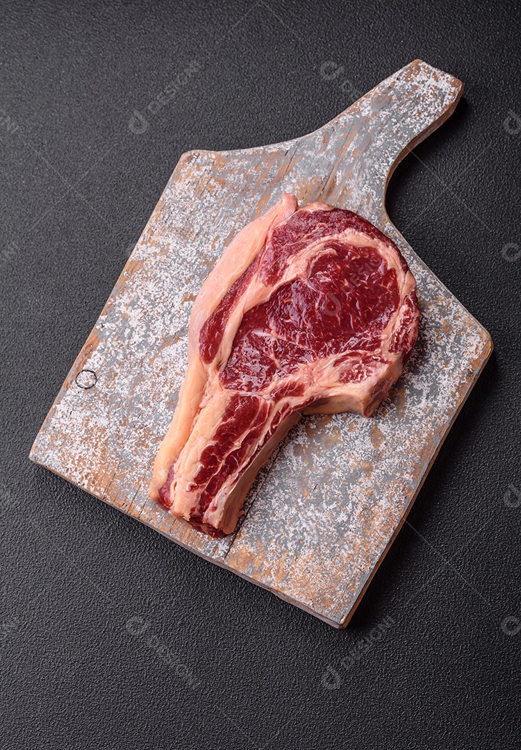 Bife de carne cru fresco sobre tábua de madeira