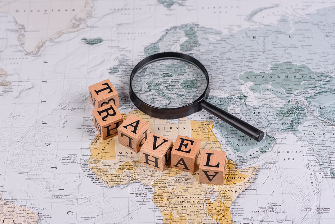 Blocos de madeira escrito viagem sobre fundo lupa mapa mundial