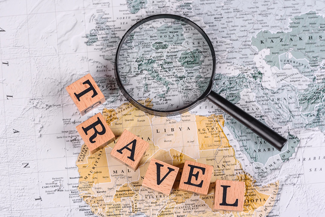 Blocos de madeira escrito viagem sobre fundo lupa mapa mundial