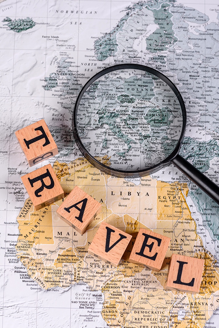 Blocos de madeira escrito viagem sobre fundo lupa mapa mundial