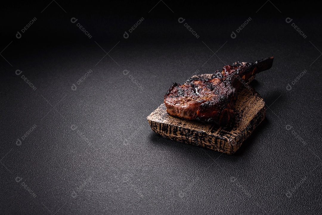 Bife fresco, suculento e delicioso em um fundo escuro. Prato de carne com especiarias e ervas