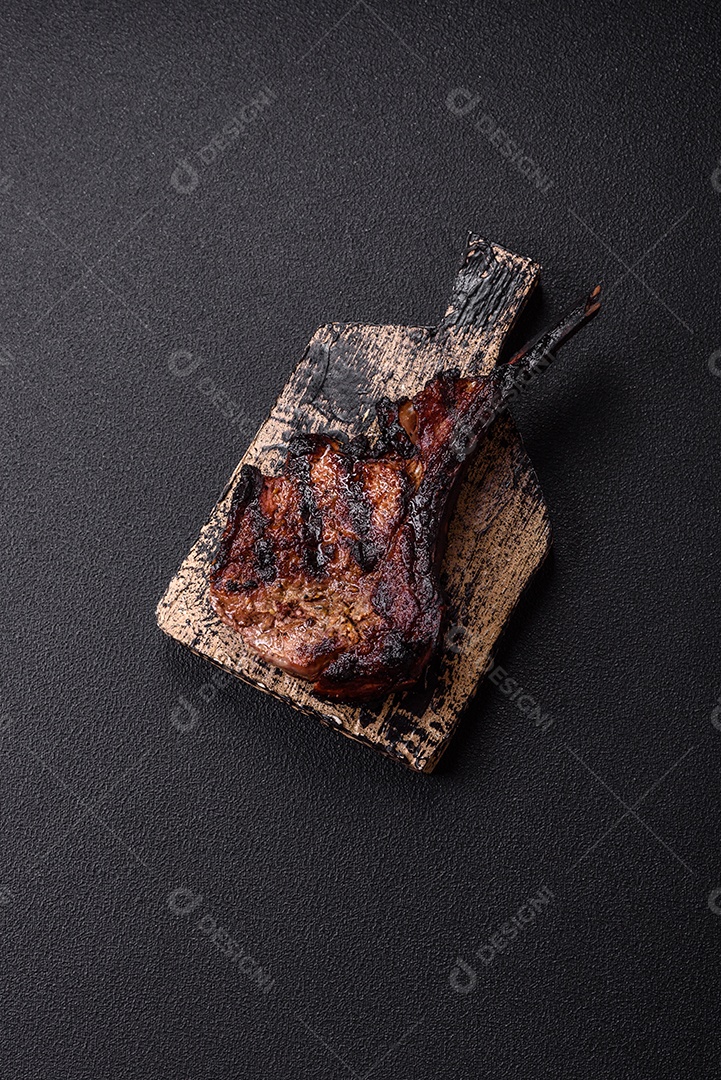 Bife fresco, suculento e delicioso em um fundo escuro. Prato de carne com especiarias e ervas