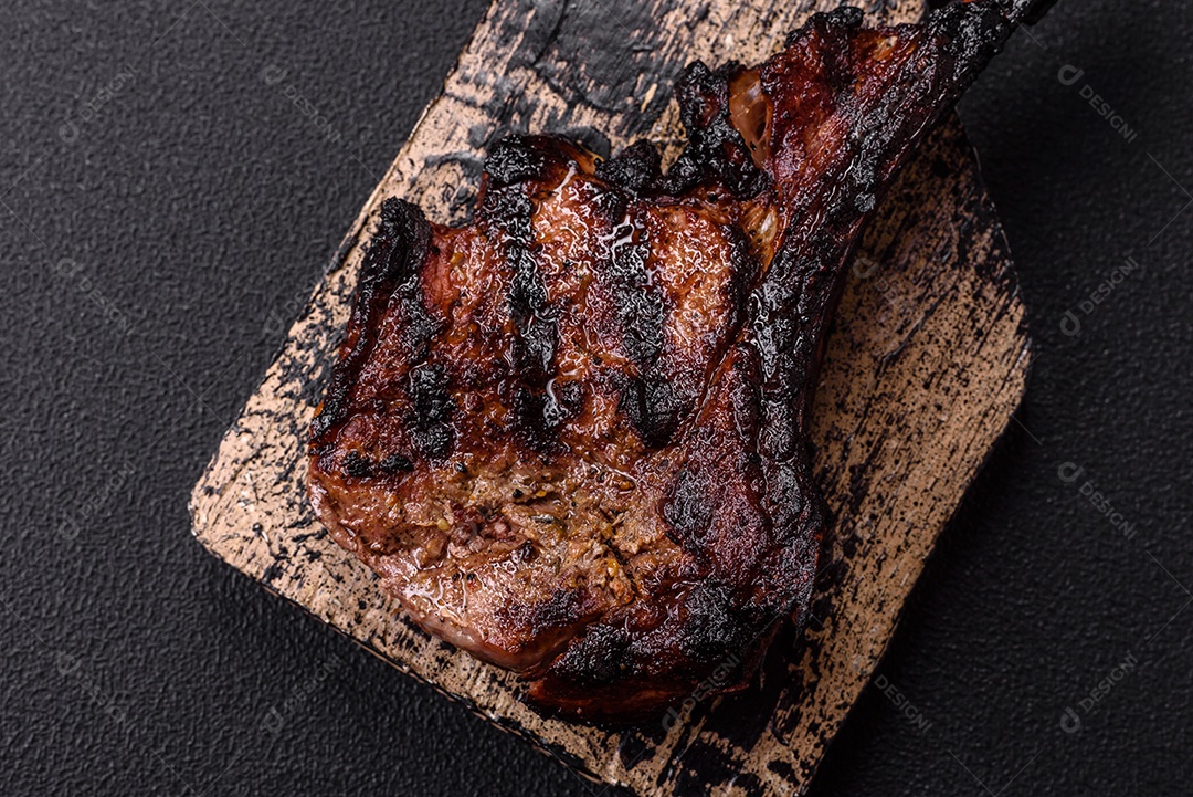 Bife fresco, suculento e delicioso em um fundo escuro. Prato de carne com especiarias e ervas