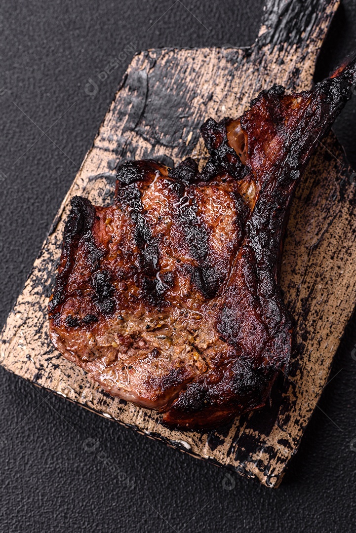 Bife fresco, suculento e delicioso em um fundo escuro. Prato de carne com especiarias e ervas