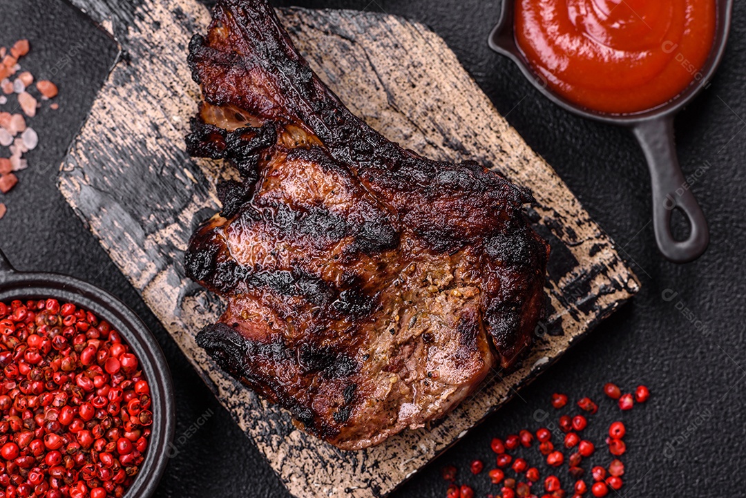 Bife fresco, suculento e delicioso em um fundo escuro. Prato de carne com especiarias e ervas