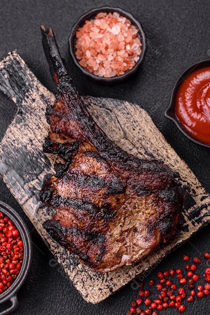 Bife fresco, suculento e delicioso em um fundo escuro. Prato de carne com especiarias e ervas