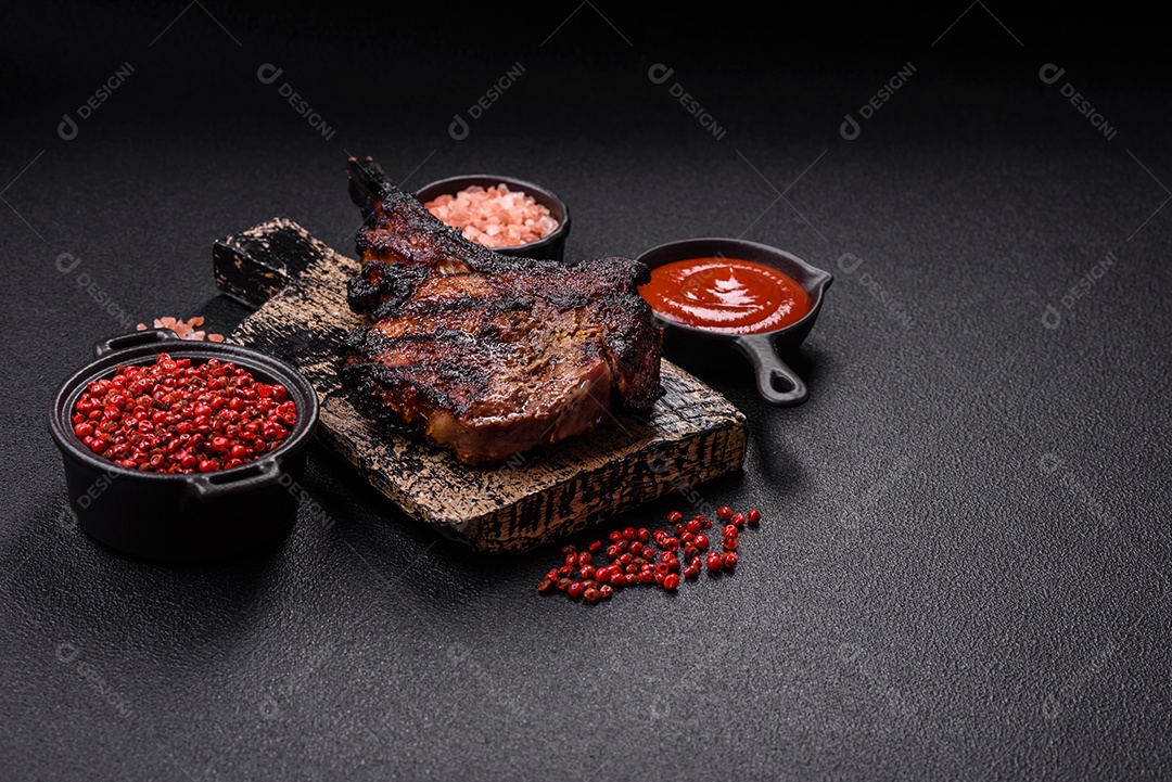 Bife fresco, suculento e delicioso em um fundo escuro. Prato de carne com especiarias e ervas