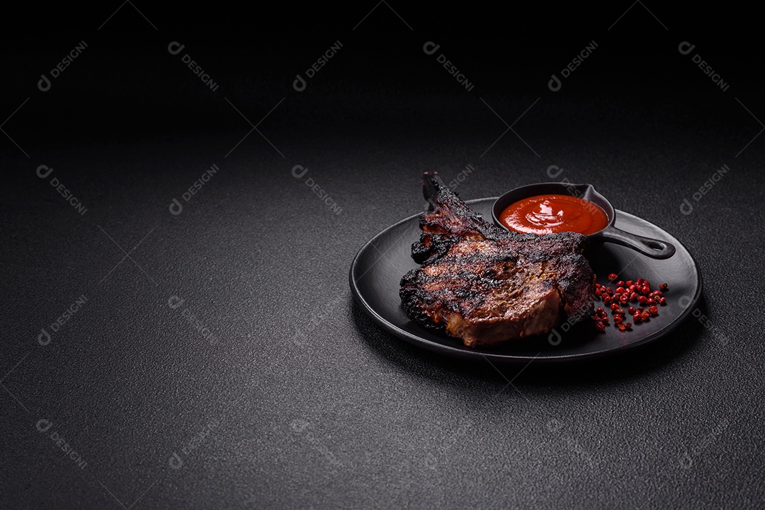 Bife fresco, suculento e delicioso em um fundo escuro. Prato de carne com especiarias e ervas