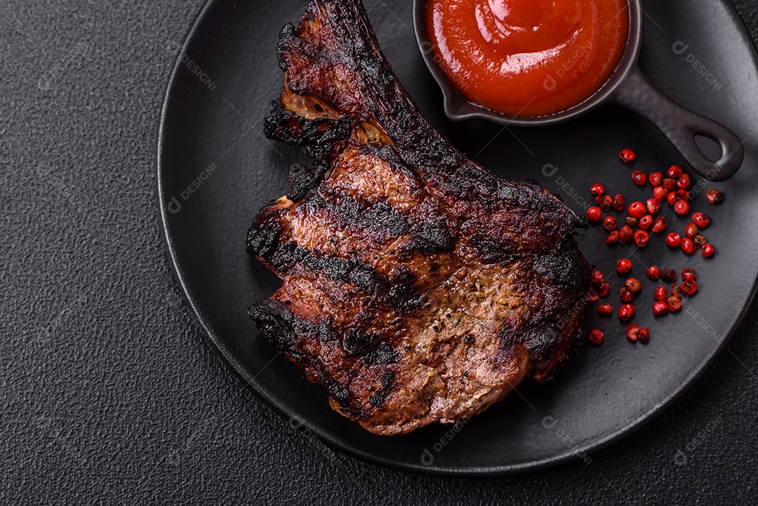 Bife fresco, suculento e delicioso em um fundo escuro. Prato de carne com especiarias e ervas