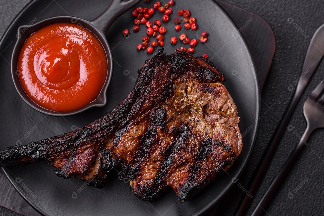 Bife fresco, suculento e delicioso em um fundo escuro. Prato de carne com especiarias e ervas