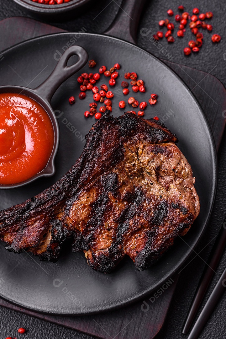 Bife fresco, suculento e delicioso em um fundo escuro. Prato de carne com especiarias e ervas